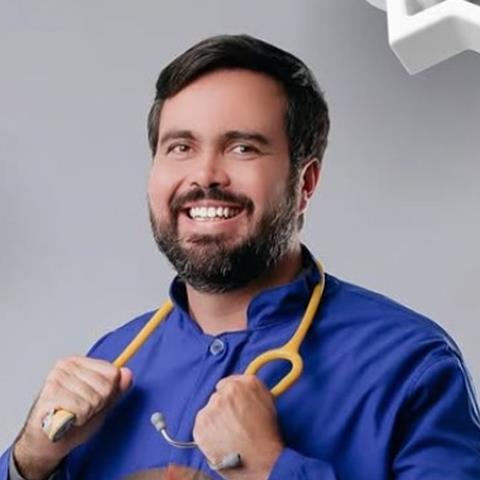 Dr. Isaac Américo, pediatra da Clínica Crescer, sorrindo com o estetoscópio no pescoço