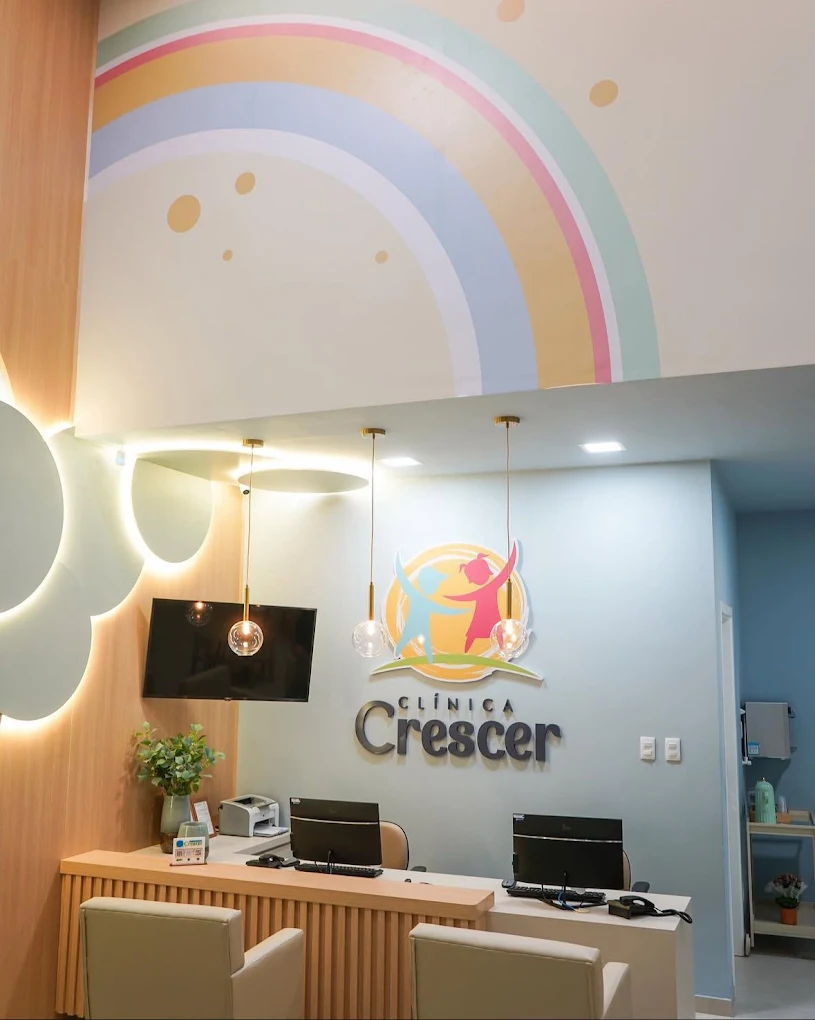 Recepção da Clínica Crescer com painel de arco-íris em tons pastel
